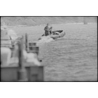 Le ponton est tracté par une barque à moteur.