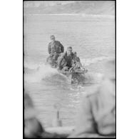 Le ponton est tracté par une barque à moteur.