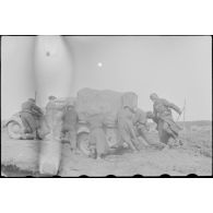 Une camionnette qui vient de s'embourber doit être poussée par des soldats.