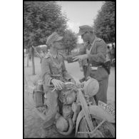 Deux Feldgendarme au milieu d'une rue lors de l'évacuation d'une ville lettone.