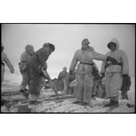 Une Kübelwagen immatriculée WH-1432 613 tente de reprendre la route, des semi-chenillés attentent de passer le pont.