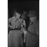 Deux soldats trinquent à l'intérieur d'un baraquement.