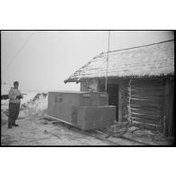 A proximité d'une isba, le reporter photographie un poste émetteur installé sur un traîneau.