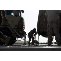 Un soldat émirien fixe des véhicules du 5e régiment de cuirassiers (RC) à bord d'un porte-engin blindé (PEB) à Zayeb military city, aux Emirats arabes unis.