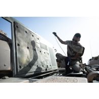 Un soldat du 5e régiment de cuirassiers (RC) intervient sur un char de combat AMX-Leclerc pour sa maintenance sur le camp d'Al Hamra, aux Emirats arabes unis.