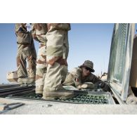 Des soldats du 5e régiment de cuirassiers (RC) interviennent sur leur char de combat AMX-Leclerc pour sa maintenance sur le camp d'Al Hamra, aux Emirats arabes unis.