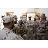 Un soldat du 92e régiment d'infanterie (RI) échange en arabe avec des militaires émiriens sur le camp de Zayed military city, aux Emirats arabes unis.