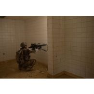 Un soldat du 92e régiment d'infanterie (RI) tire à la mitrailleuse FN Minimi dans un bâtiment du camp de Zayed military city, aux Emirats arabes unis.