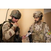 Un commandant d'unité du 92e régiment d'infanterie (RI) se coordonne avec son homologue émirien pour une progression dans un bâtiment du camp de Zayed military city, aux Emirats arabes unis.