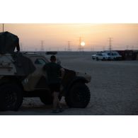 Un soldat du 5e régiment de cuirassiers (RC) observe le coucher du soleil depuis son véhicule blindé léger (VBL) sur le camp d'Al Hamra, aux Emirats arabes unis.