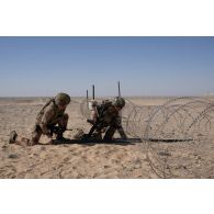 Des sapeurs du 17e régiment du génie parachutiste (RGP) placent une charge allongée pour ouvrir une brèche dans un couloir de fils barbelés dans la région d'Al Hamra, aux Emirats arabes unis.