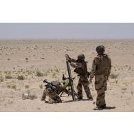 Un tireur du 92e régiment d'infanterie (RI) place un obus dans un mortier de 81 mm léger long renforcé (LLR) dans la région d'Al Hamra, aux Emirats arabes unis.