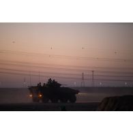 Un véhicule blindé de combat d'infanterie (VBCI) progresse au coucher du soleil dans la région d'Al Hamra, aux Emirats arabes unis.