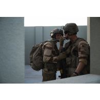Un soldat du 92e régiment d'infanterie (RI) se désaltère au moyen du sac à dos camelback de son camarade sur le camp d'Al Hamra, aux Emirats arabes unis.