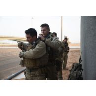 Des soldats du 92e régiment d'infanterie (RI) enfilent leur tenue de protection à port permanent (T3P) pour une progression en milieu contaminé sur le camp d'Al Hamra, aux Emirats arabes unis.