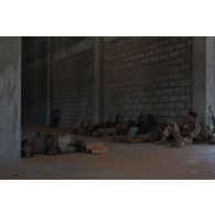 Un groupe de combat du 92e régiment d'infanterie (RI) se repose à l'abri d'un bâtiment à la tombée de la nuit sur le camp d'Al Hamra, aux Emirats arabes unis.