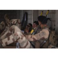 Un groupe de combat du 92e régiment d'infanterie (RI) se repose à l'abri d'un bâtiment à la tombée de la nuit sur le camp d'Al Hamra, aux Emirats arabes unis.