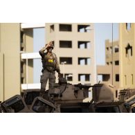 Un soldat du 92e régiment d'infanterie (RI) observe le terrain depuis le toit d'un véhicule de l'avant blindé (VAB) sur le camp d'Al Hamra, aux Emirats arabes unis.