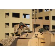 Un chef de char du 5e régiment de cuirassiers (RC) coordonne son équipage à bord de leur char de combat AMX-Leclerc sur le camp d'Al Hamra, aux Emirats arabes unis.