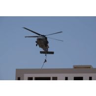 Un hélicoptère Sikorsky UH-60M Black Hawk dépose des soldats émiriens par corde lisse sur le toit d'un bâtiment du camp d'Al Hamra, aux Emirats arabes unis.