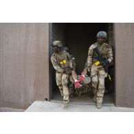 Des soldats du 92e régiment d'infanterie (RI) évacuent leur camarade simulant une blessure sur le camp d'Al Hamra, aux Emirats arabes unis.