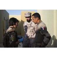 Le médecin des armées Cécile se coordonne avec son homologue émirien grâce à un interprète à l'antenne médicale du camp d'Al Hamra, aux Emirats arabes unis.