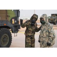 Un soldat du 2e régiment de dragons (RD) se coordonne avec son homologue émirien pour manoeuvrer une chaîne de décontamination sur le camp d'Al Hamra, aux Emirats arabes unis.