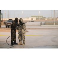 Un soldat du 2e régiment de dragons (RD) se coordonne avec son homologue émirien pour manoeuvrer une chaîne de décontamination sur le camp d'Al Hamra, aux Emirats arabes unis.