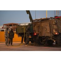 Des soldats du 2e régiment de dragons (RD) décontaminent un véhicule blindé de combat d'infanterie (VBCI) sur le camp d'Al Hamra, aux Emirats arabes unis.