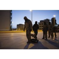 Des soldats du 2e régiment de dragons (RD) supervisent la décontamination d'un groupe de combat du 92e régiment d'infanterie (RI) sur le camp d'Al Hamra, aux Emirats arabes unis.
