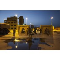 Des soldats du 2e régiment de dragons (RD) supervisent la décontamination d'un groupe de combat du 92e régiment d'infanterie (RI) sur le camp d'Al Hamra, aux Emirats arabes unis.