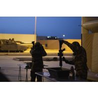 Des soldats du 2e régiment de dragons (RD) décontaminent des fusils d'assaut HK-416 sur le camp d'Al Hamra, aux Emirats arabes unis.