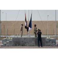 L'opérateur vidéo Simon de l'ECPAD filme le lever des couleurs sur la place d'armes de Zayed military city, aux Emirats arabes unis.
