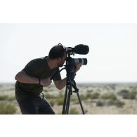 L'opérateur vidéo Simon de l'ECPAD filme au milieu du désert à Zayed military city, aux Emirats arabes unis.