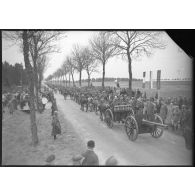 Sur une route, les troupes polonaises (75 mm M1897 hippomobile) défilent devant les officiels civils et militaires, polonais et français.