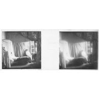 [Maroc : une infirmière dans un intérieur avec rideaux et moustiquaire]. [Légende d'origine]