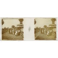 [Portrait de groupe avec infirmières et population devant un véhicule].<br>