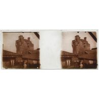 [Vue d'une tour avec infirmière devant du linge étendu au premier plan].