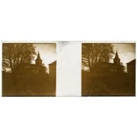 [Vue d'une église. Une femme est photographiée dans la rue au premier plan].<br>