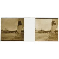 [Cérémonie militaire à Longchamp ? : vue générale avec drapeau à croix rouge au premier plan].<br>