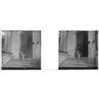 [Femme donnant à manger à son chien sur le perron d'un immeuble].<br>