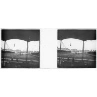 [Spectacle acrobatique sur un terrain rectangulaire bordé de tribunes, rangée d'immeubles au second plan].<br> [Légende d'origine]