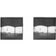 [Spectacle équestre sur un terrain rectangulaire bordé de tribunes, rangée d'immeubles au second plan].<br>