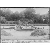 Portière double - relevage des ancres, la portière étant poussée par un bateau propulseur. [légende d'origine]