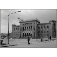 La bibliothèque de Sarajevo, incendiée le 25 août 1992 (elle comptait alors un million de volumes). Ici en reconstruction. [légende d'origine]