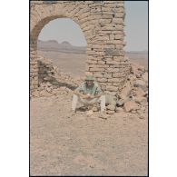 Le major Rémi Labbée pose sous l'arche des ruines du décor de cinéma réalisé pour le film "Fort Saganne". [légende d'origine]<br>