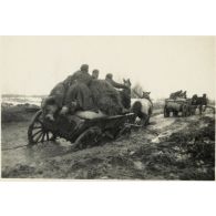 [Un convoi hippomobile sur une route détrempée].
