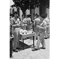 Cour du quartier de l'EM de la 21e DI à Batna : préparation d'un méchoui à l'occasion de la Saint-Gabriel. [légende d'origine]