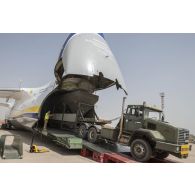 Déchargement d'une centrale d'enrobage à bitume tractée par un camion Renault CBH-380, depuis la soute d'un Antonov An 124-100 stationnant sur le tarmac de la Base aérienne 172 Fort-Lamy à N'Djamena.