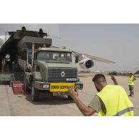Déchargement d'une centrale d'enrobage à bitume tractée par un camion Renault CBH-380, depuis la soute d'un Antonov An 124-100 stationnant sur le tarmac de la Base aérienne 172 Fort-Lamy à N'Djamena.